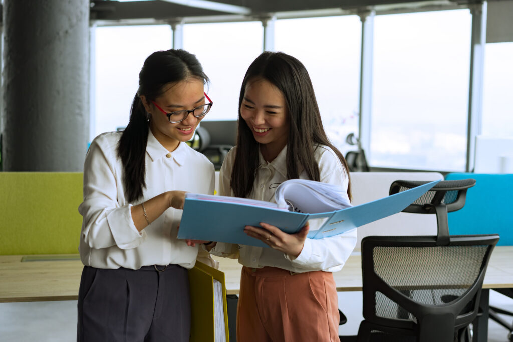 Two colleagues reviewing documents in a bright office